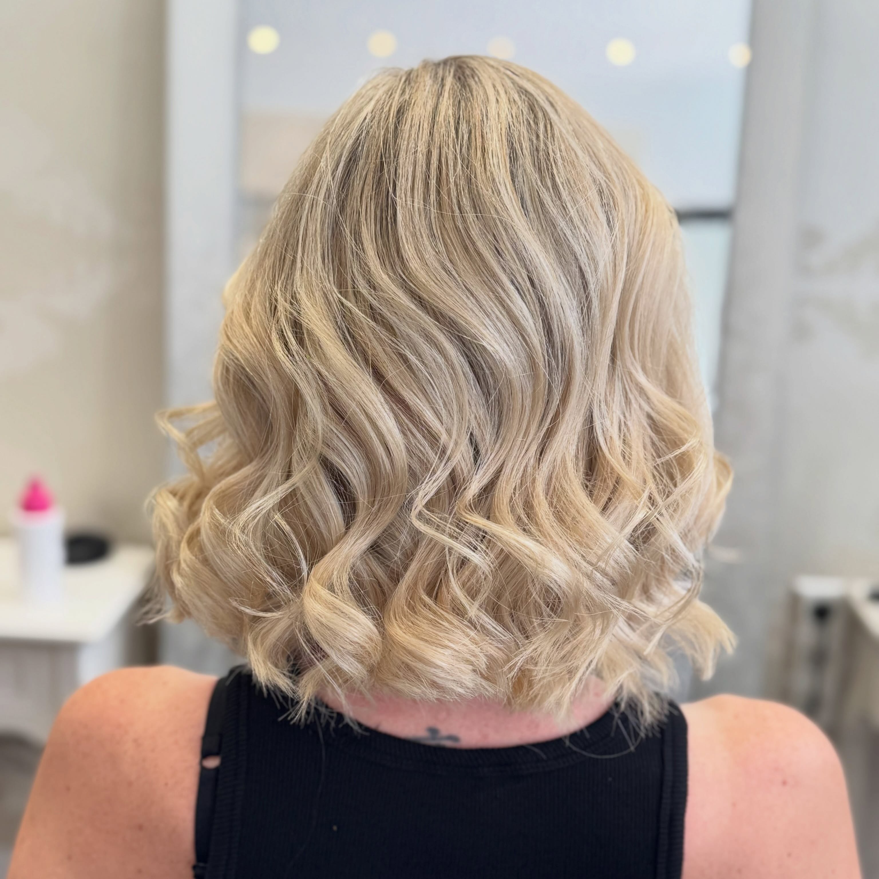 Blonde Locken im Salonspiegel, Art of Hair Hofheim