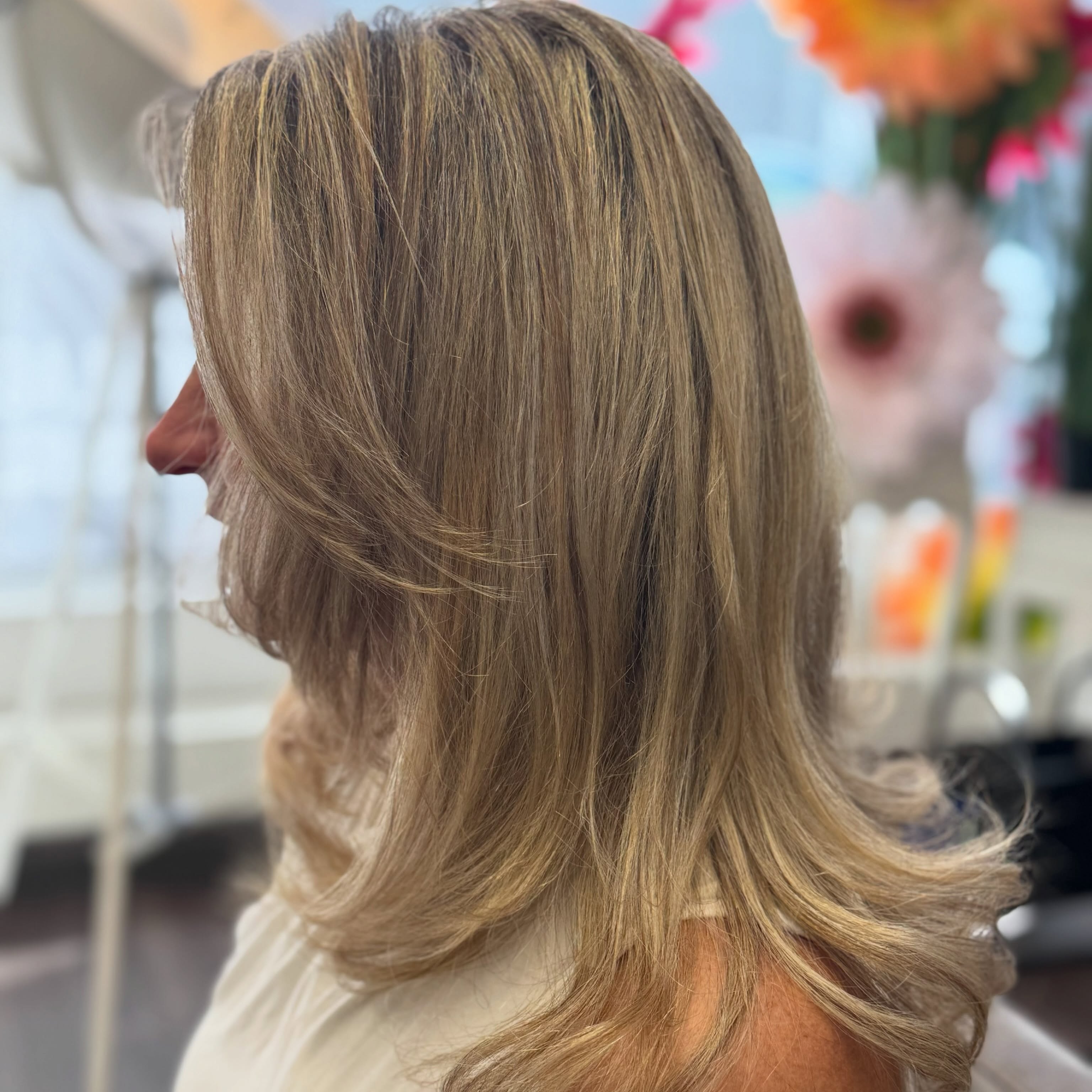 Balayage im Profil, Salon mit Blumendeko